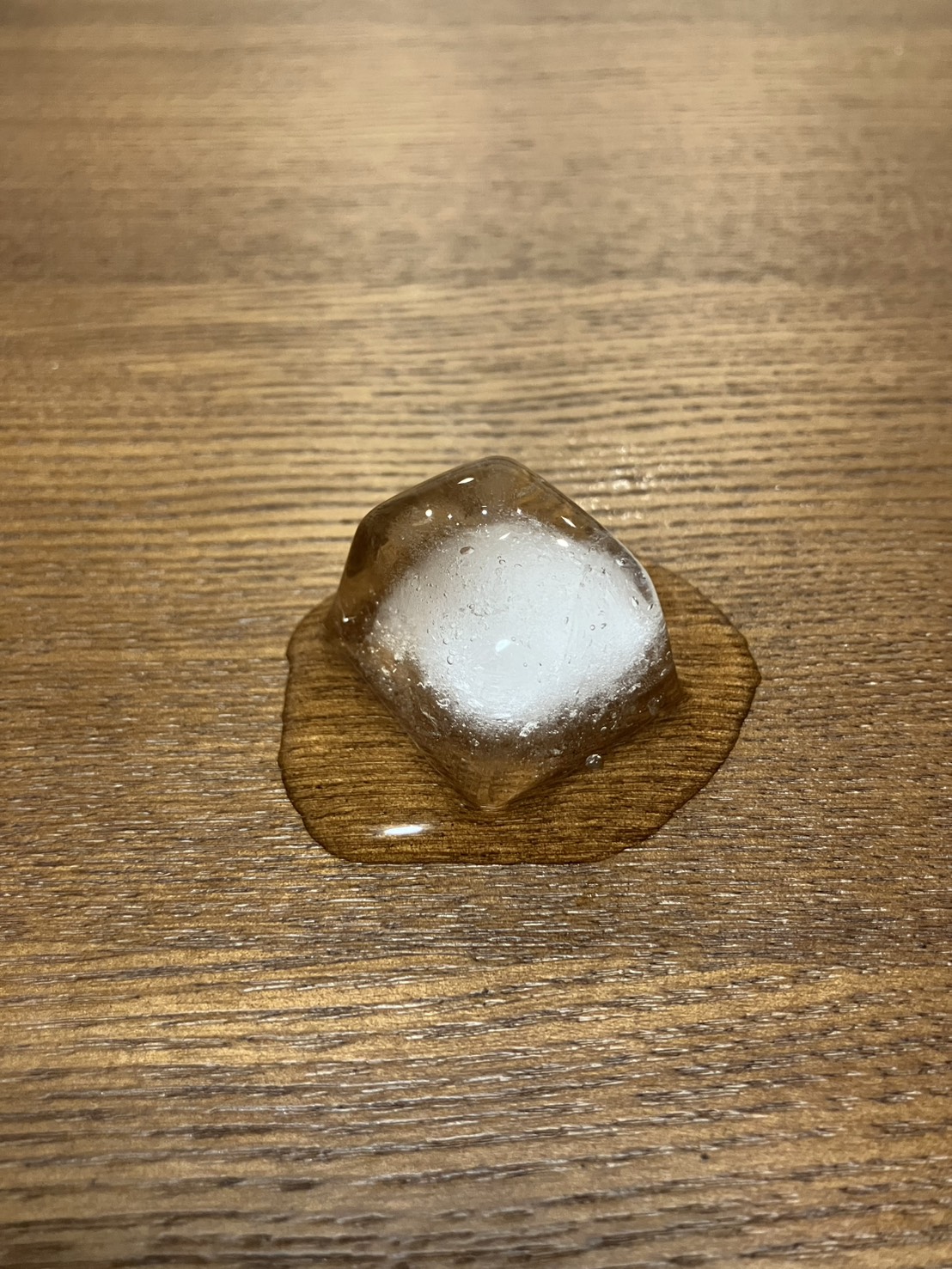 木のテーブルの上で溶け始めた氷